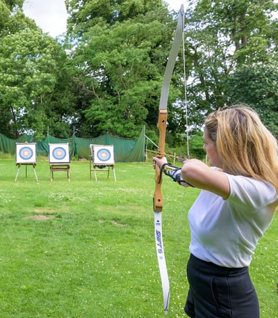 A guest aiming for the target during an archery session at Studley Castle Hotel