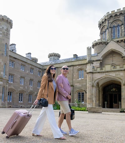 Couple with bags outside hotel 