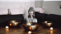 Buddha head surrounded by three sound bowls