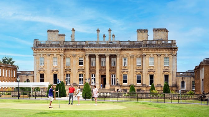 Guests playing golf in front of Heythrop Park Hotel
